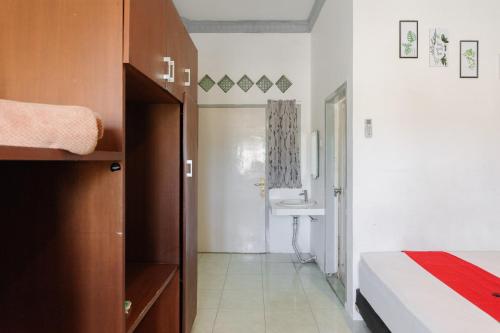 a bedroom with a bed and a bathroom with a sink at RedDoorz Syariah near Suzuya Mall Banda Aceh in Banda Aceh