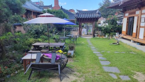 une terrasse avec une table et un parasol dans l'établissement Hanok Hyeyum, à Jeonju