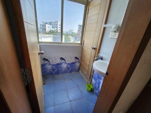 Elle comprend une petite salle de bains pourvue d'un lavabo et d'une fenêtre. dans l'établissement SCK Home Stay, à Hyderabad