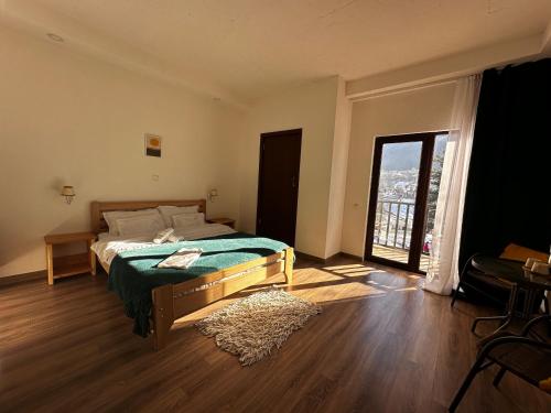 a bedroom with a bed and a large window at "White House Nakani" - Guesthouse near the centre in Mestia