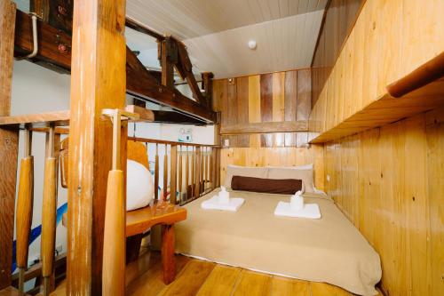 a bedroom with a bed in a wooden cabin at Antonio's Bed and Breakfast Hotel in Balogo
