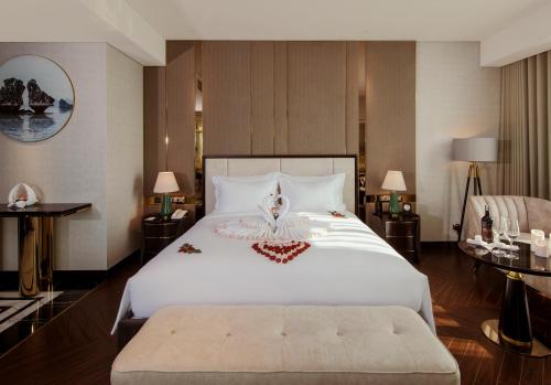 a bedroom with a large white bed and two tables at Radisson Blu Ha Long Bay in Ha Long