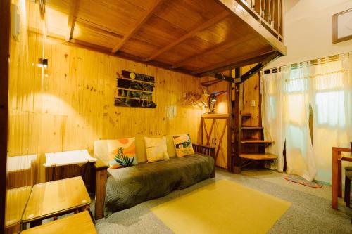 a living room with a couch and a wooden wall at Antonio's Bed and Breakfast Hotel in Balogo