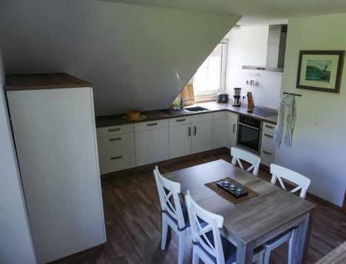 uma cozinha com uma mesa e cadeiras e um frigorífico em „Kiekut“ Ferienwohnung em Fehmarn