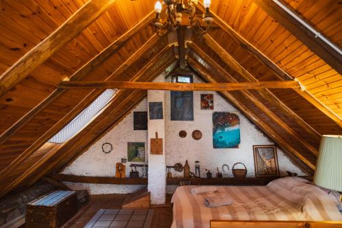 a bedroom in a wooden attic with a bed at Country House Atelier in Zvoneće