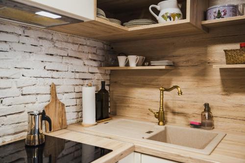 a kitchen with a sink and a brick wall at Country House Atelier in Zvoneće