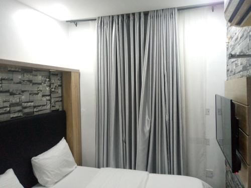 um quarto de hotel com uma cama e uma janela em Exclusive mansion lekki phase 1 em Ilado