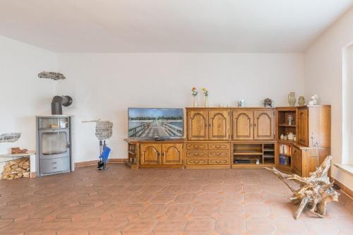 a kitchen with wooden cabinets and a tv in a room at Ferienwohnung Erika in Dassow