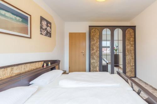 a bedroom with a large white bed and a window at Ferienwohnung Erika in Dassow