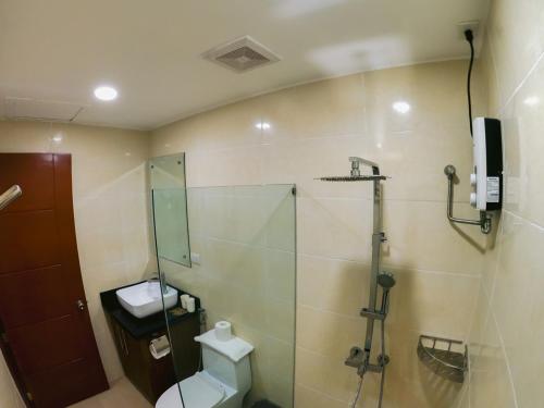 a bathroom with a shower and a toilet and a sink at Cris Inn Tagum in Tagum