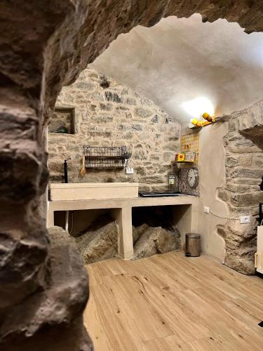 a stone room with a table in a stone wall at La Finestra di Dante in Mulazzo