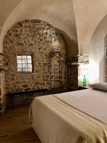 a bedroom with a bed and a stone wall at La Finestra di Dante in Mulazzo