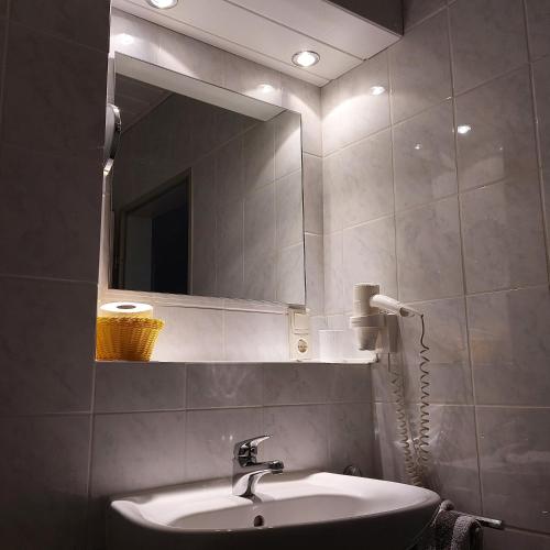 y baño con lavabo y espejo. en Gästehaus Therme-Blick en Bad Driburg
