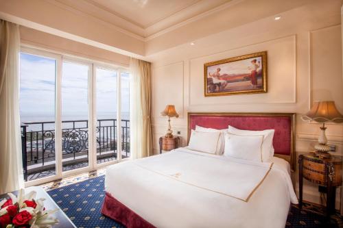 a bedroom with a large bed and a large window at The IMPERIAL Vung Tau Hotel in Vung Tau