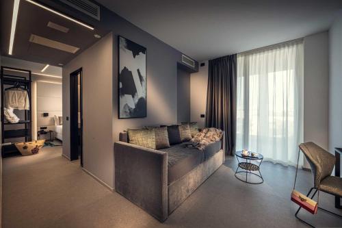 a living room with a couch and a large window at J44 Lifestyle Hotel in Lido di Jesolo