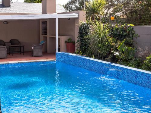 uma piscina azul em frente a uma casa em Julinas Guesthouse em Parow