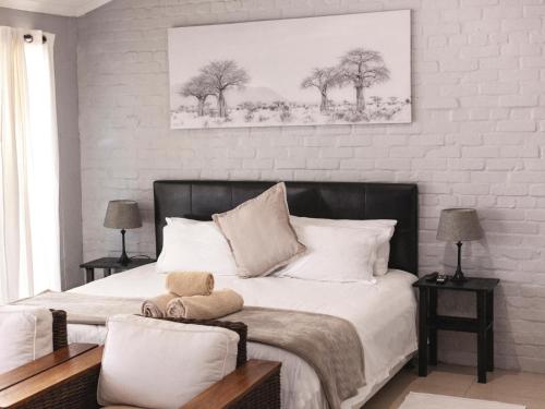 um quarto com uma cama grande e paredes brancas em Julinas Guesthouse em Parow