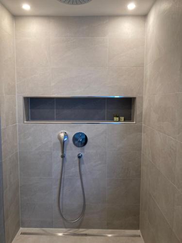 a shower with a hose in a bathroom at Alma - Art Luxus Modern Ambiente in Karlsruhe