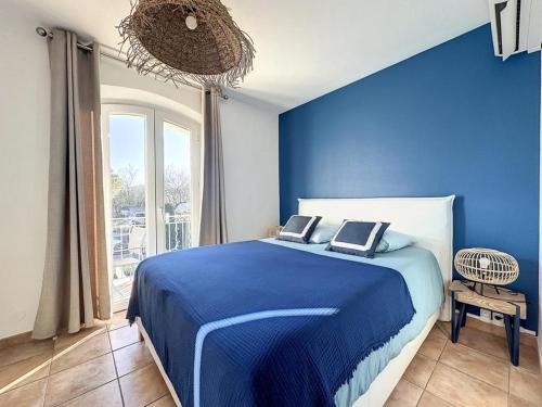 a blue bedroom with a bed with two laptops on it at Le Clos de Saint Aygulf in Saint-Aygulf