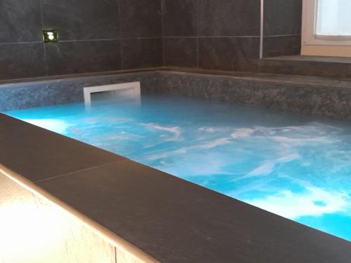 a bath tub filled with blue water in a room at Hotel Mia Cara & Spa in Florence