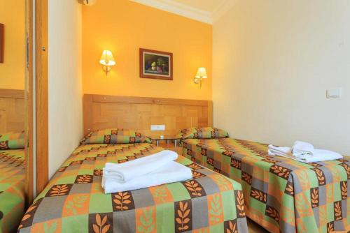 two beds in a hotel room with towels on them at Orka World Hotel & Aquapark in Oludeniz