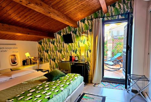 a bedroom with a bed and a sliding glass door at La Foresteria Garden Boutique B&B in Catania