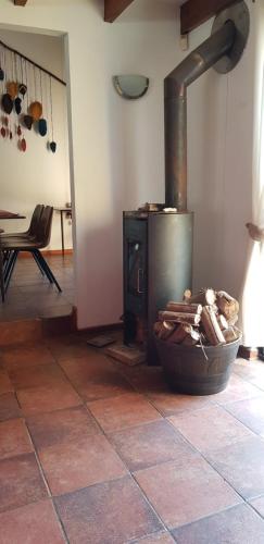 a stove in a room with a basket of wood at Casa Felice Altovalsol in La Serena