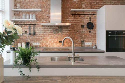 a kitchen with a sink and a brick wall at Kampervest Apartment Haarlem in Haarlem