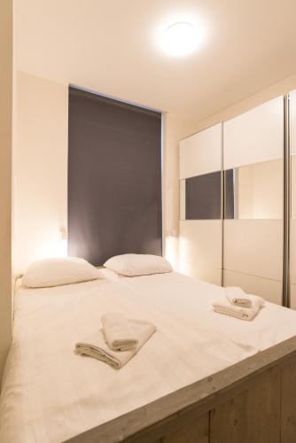 a large white bed with two towels on it at Canal House Haarlem in Haarlem