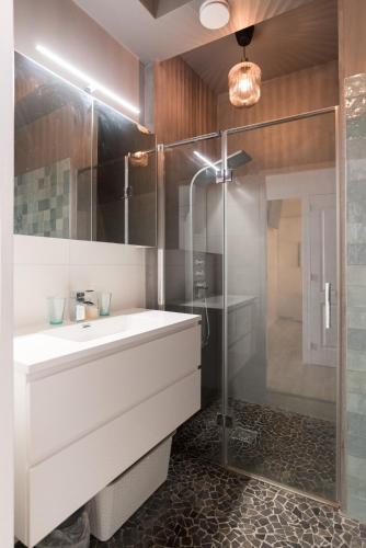 a bathroom with a white sink and a shower at Canal House Haarlem in Haarlem