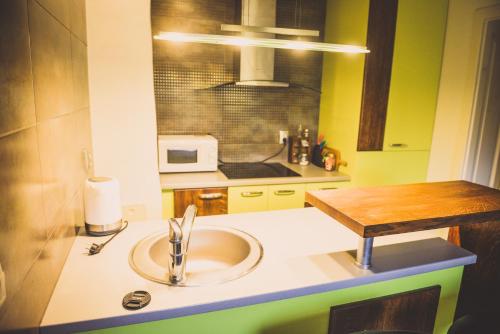 a kitchen with a sink and a microwave at Ubytovanie Nitrianske Pravno in Prievidza