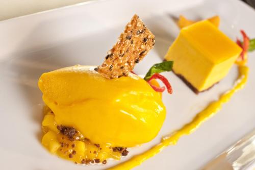 a white plate with a piece of yellow dessert at Dorint Hotel Frankfurt/Oberursel in Oberursel