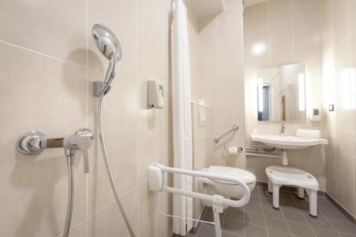 uma casa de banho com um chuveiro e um lavatório. em B&B HOTEL Sainte-Maxime Golfe de Saint Tropez em Sainte-Maxime