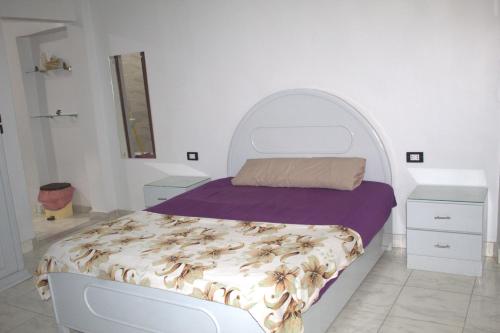 a bedroom with a bed and two night stands at Abeer Guest House in Luxor