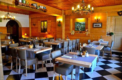 Un restaurante con mesas y sillas y suelo de cuadros. en Hotel Floralp, en La Clusaz