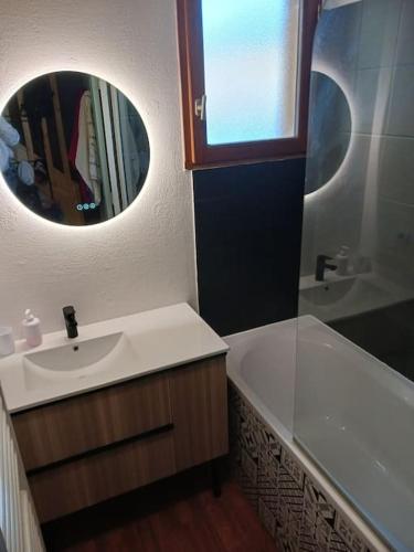 a bathroom with a sink and a tub and a mirror at Chalet 6 personnes Super Dévoluy in Superdevoluy