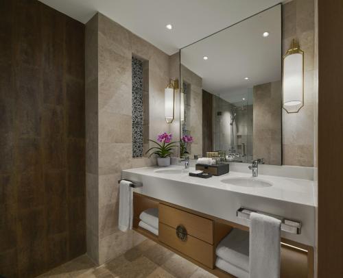 a bathroom with two sinks and a large mirror at PARKROYAL A'FAMOSA MELAKA RESORT in Kampong Alor Gajah