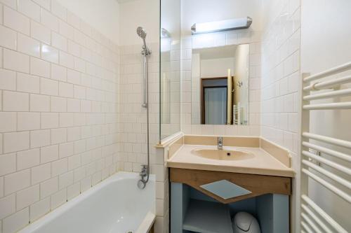 ein Badezimmer mit einem Waschbecken, einer Dusche und einer Badewanne in der Unterkunft Le Swing - Résidence avec piscine chauffée in Deauville