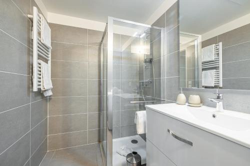 a bathroom with a shower and a sink and a mirror at Beautiful New Apartment in Menton