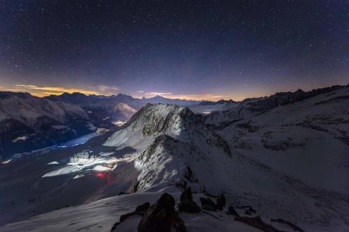 a night view of a mountain with a star filled sky at CHRIStania in Fiesch
