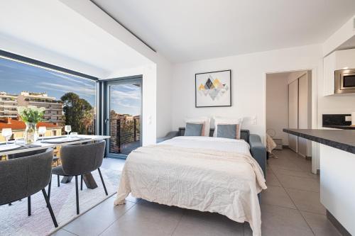 Cet appartement comprend une chambre avec un lit et une cuisine avec une table. dans l'établissement Beautiful New Apartment, à Menton