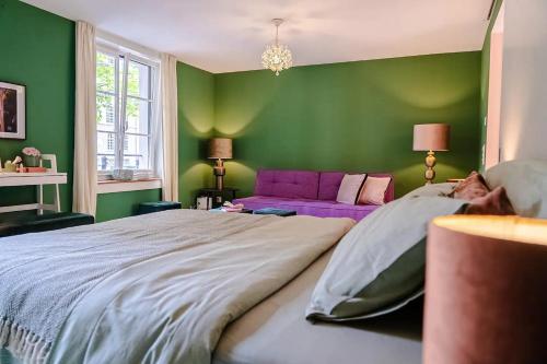 a green bedroom with a large bed and a purple couch at Stylish Garden-Gem by Lake: Pet-Friendly & Central in Zürich