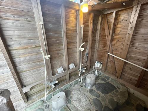een badkamer met 2 toiletten in een houten gebouw bij Sea Garden Villa Shodoshima in Kusakabe