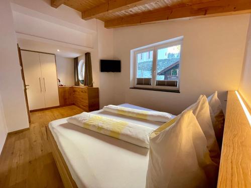 Un dormitorio con una cama grande y una ventana en Ferienwohnungen Sandro Steiner, en Prägraten am Großvenediger
