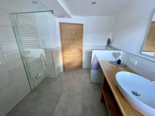 een badkamer met een wastafel en een glazen douche bij Ferienwohnungen Sandro Steiner in Prägraten