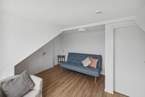 a living room with a blue couch with two pillows at Marianne in Büsum
