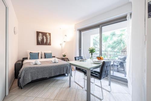 une chambre avec un lit, une table et une fenêtre dans l'établissement Studio Centre Terrasse Climatisation 50m plage, à Menton