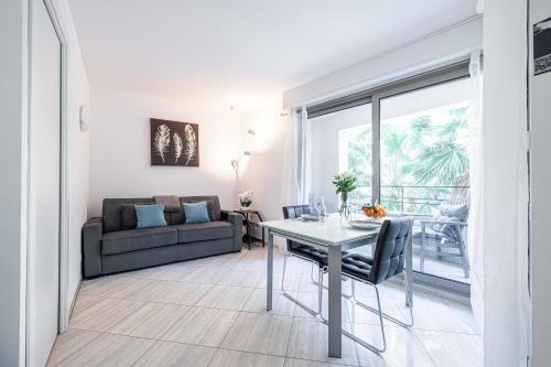 un salon avec une table et un canapé dans l'établissement Studio Centre Terrasse Climatisation 50m plage, à Menton