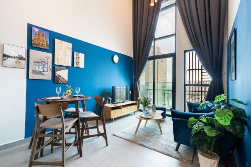 un soggiorno con pareti blu e tavolo e sedie di DingD0ng Home FelizEnVista 5-star facilities ad Ho Chi Minh