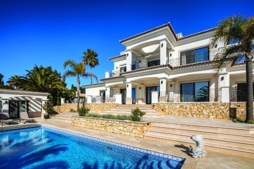 a house with a swimming pool in front of it at Casa Ceu Branco in Carvoeiro